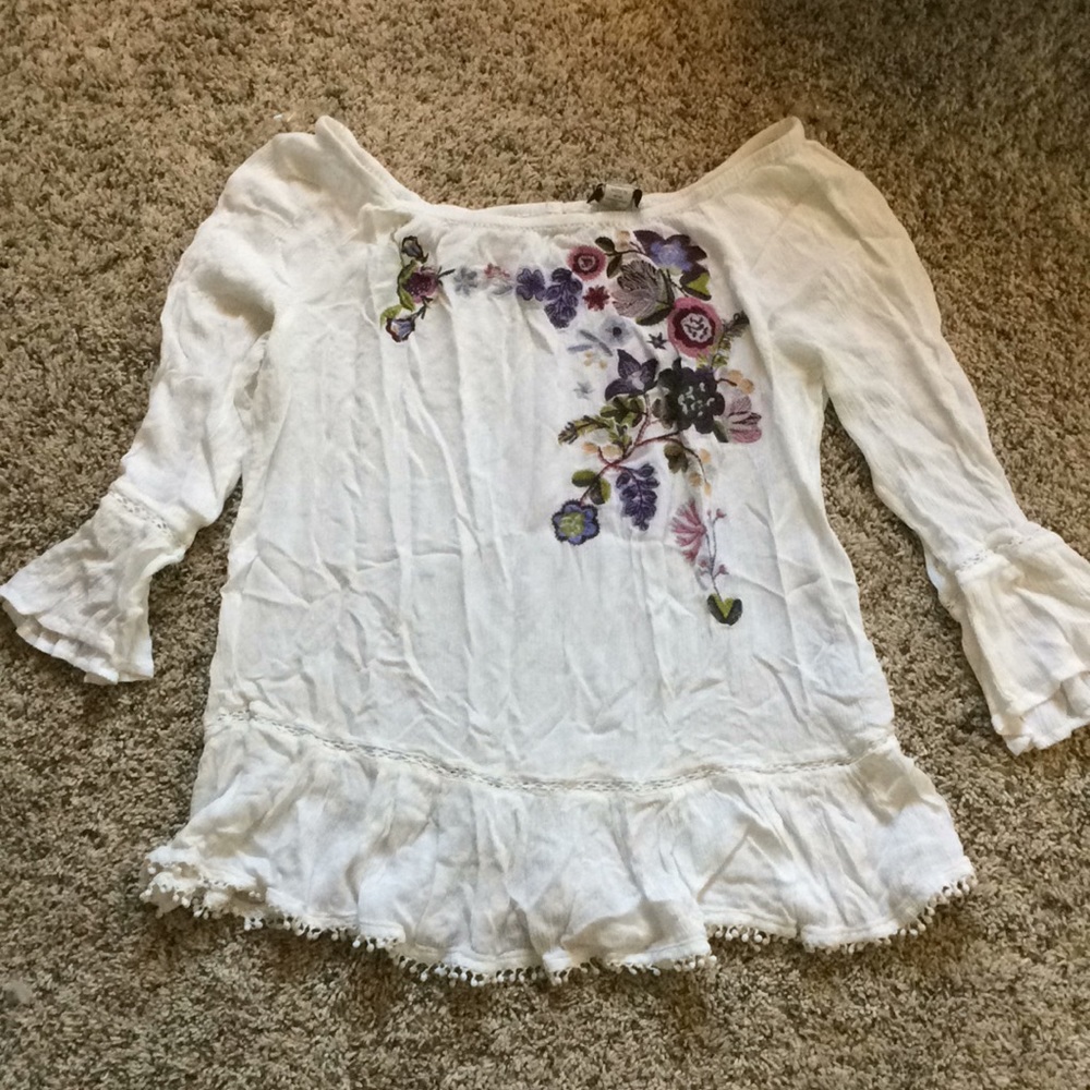 White flowy top with floral embroidery detail